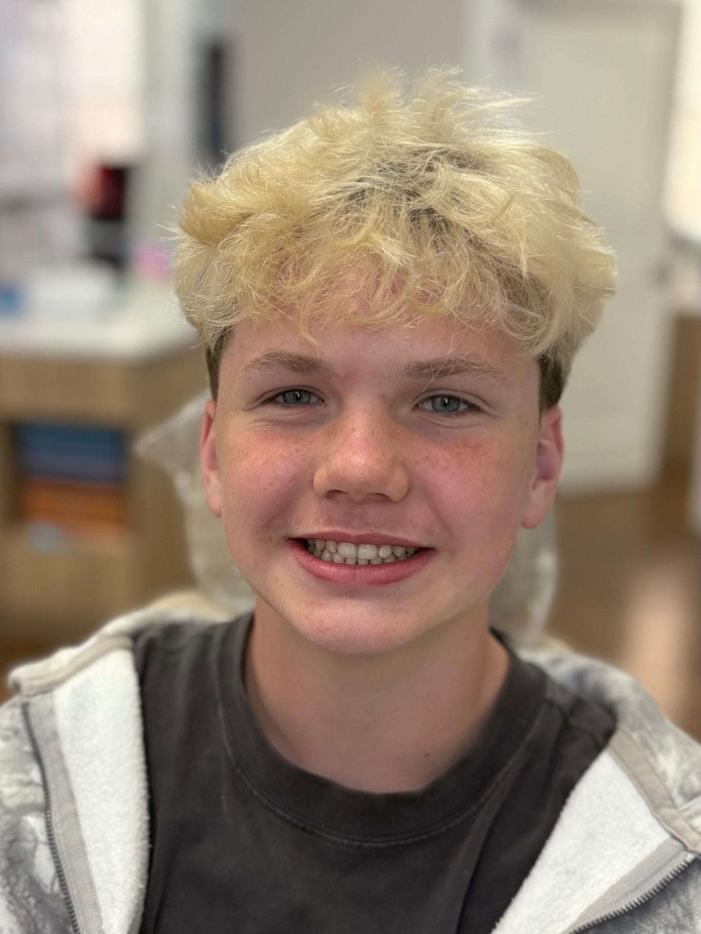 Young orthodontics patient smiling in a treatment chair